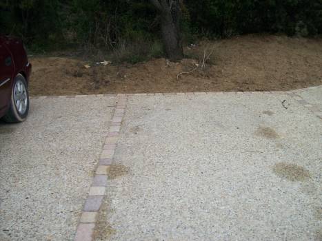 Jonction pavée entre deux places de parking réalisées en béton