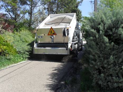 PATA en train de répendre les graviers du bicouche sur un chantier à Eguilles