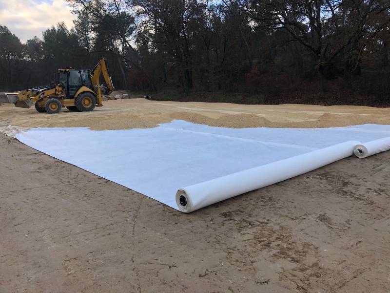 Pose d'un voile géotextile avant grave non traitée compactée pour chantier d'une aire de stationnement dans le 13
