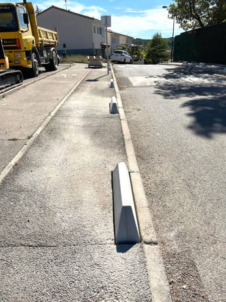 Installation de bornes anti-stationnement en béton sur chemin piétonnier à Fuveau